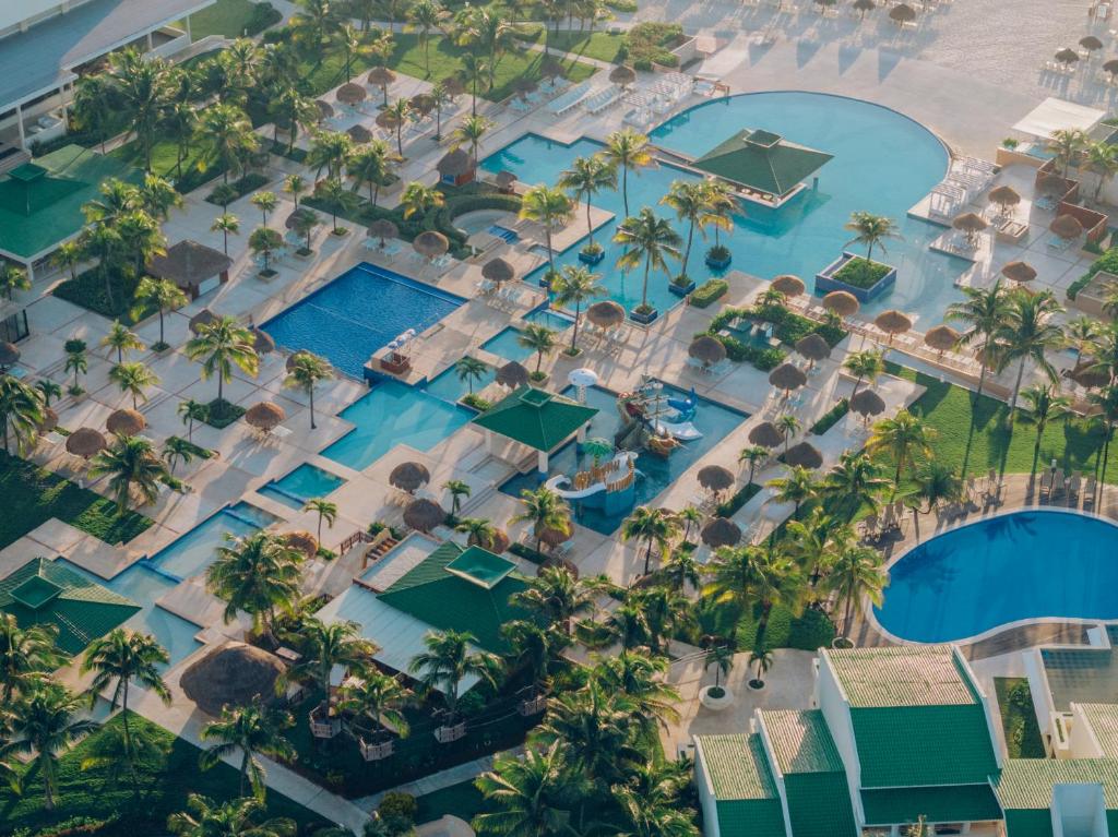 Tūrisma kompleksa skats no augšas ar vairākiem baseiniem un palmu stādījumiem, kas rada relaksējošu atmosfēru. Ideāla vieta atpūtai un izklaidei.
