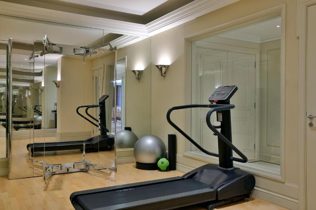 Mūsdienīgs trenažieru stūrītis ar skrejceliņu, lielu spoguli un dažādiem sporta aksesuāriem, piemēram, fitnesa bumbu un hanteli. Ideāla vide vingrošanai un veselīga dzīvesveida uzturēšanai.