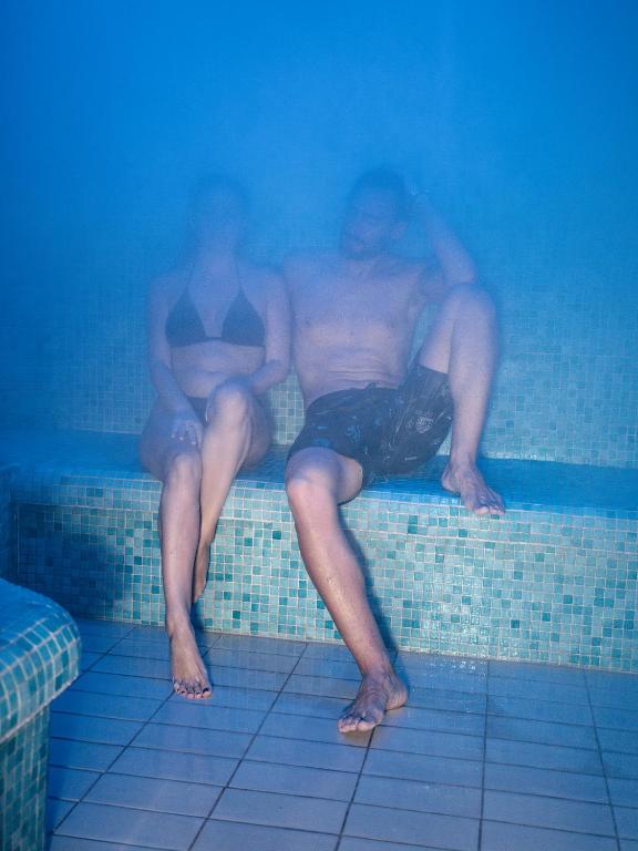 Pāris relaksējas tvaika pirtī, izbaudot siltumu un miglainu atmosfēru. Ideāla vieta atpūtai un stresa mazināšanai.