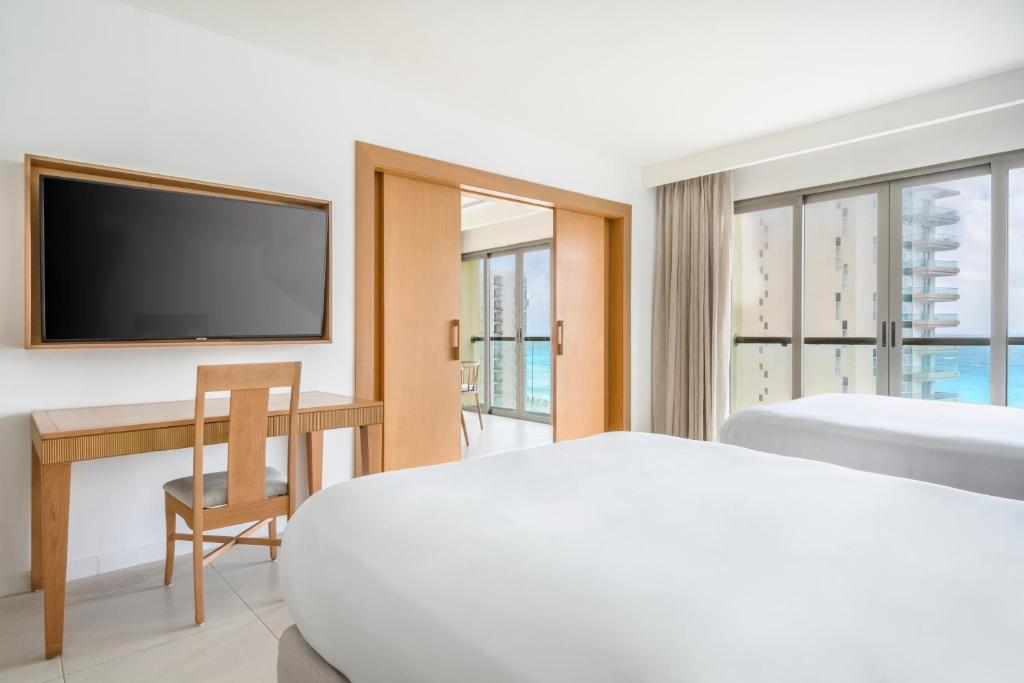 Mūsdienīgs viesnīcas numurs ar diviem gultām, rakstāmgaldu un lielu televizoru. Logi piedāvā skatu uz jūru, radot mierīgu atmosfēru.