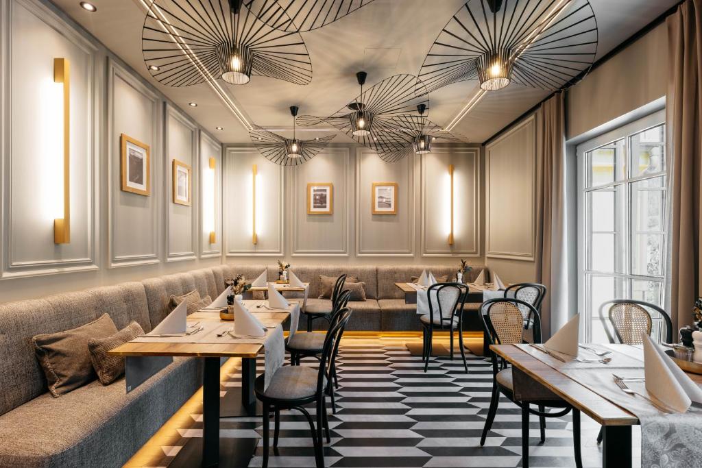 Mūsdienīgs restorāna interjers ar elegantu apgaismojumu, stilīgiem galdiem un krēsliem, kā arī dekoratīvām sienām un griestiem. Ideāla vide, lai izbaudītu maltīti.