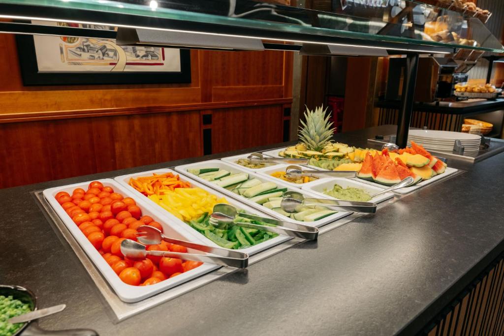 Svaigu dārzeņu un augļu bufete ar izkārtotiem tomātiem, gurķiem, ananāsu un arbūzu šķēlēm. Ideāli piemērota veselīgam ēdienam.