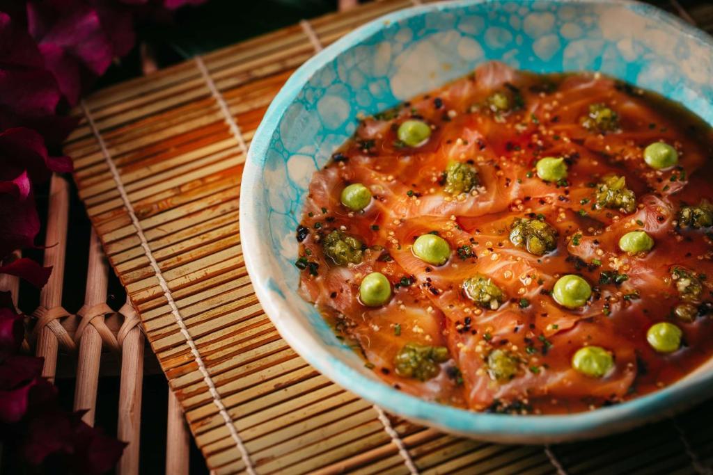 Svaiga un krāsaina sashimi šķīvis ar marinētiem dārzeņiem un garšvielām, pasniegts ornamentētā traukā. Ideāls piemērs japāņu virtuves estētikai un garšām.
