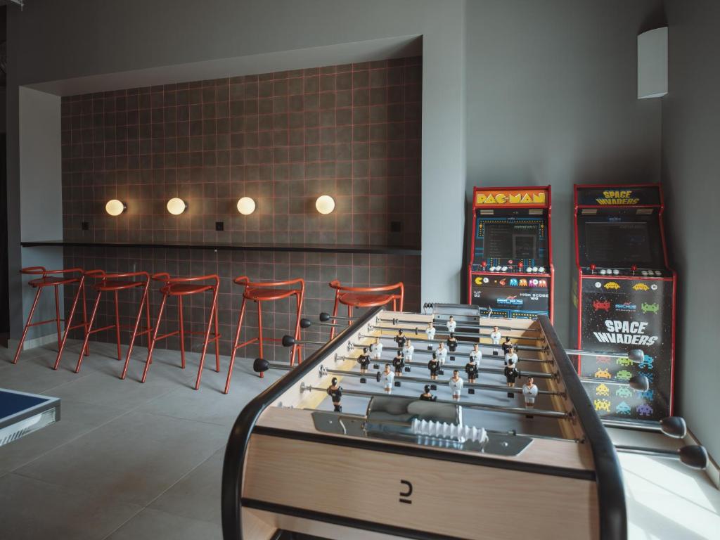 Moderns spēļu stūris ar galda futbolu, retro arcade spēļu automātiem 