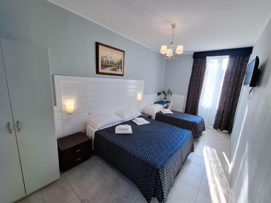 Mūsdienīga viesnīcas numura iekārtojums ar divām gultām, gaišu interjeru un logu ar aizkariem, kas ļauj ieplūst dabiskajai gaismai. Numurā ir televizors un mājīgs apgaismojums.