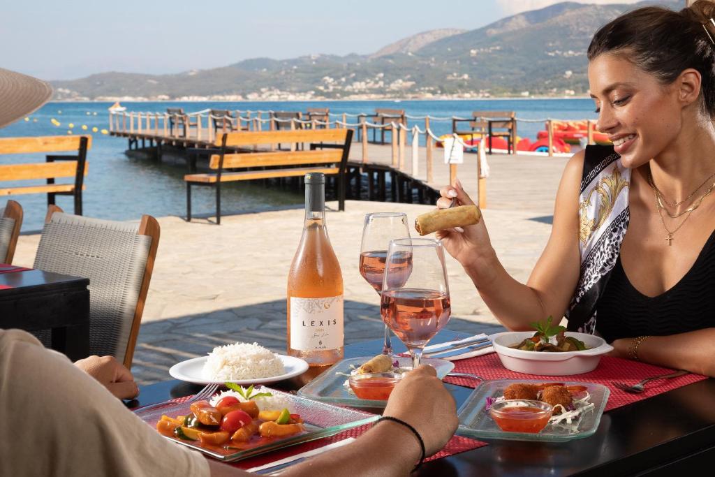 Romantiska maltīte pie jūras ar rozā vīnu un dažādiem ēdieniem. Ideāla atmosfēra brīvdienām vai īpašiem mirkļiem.