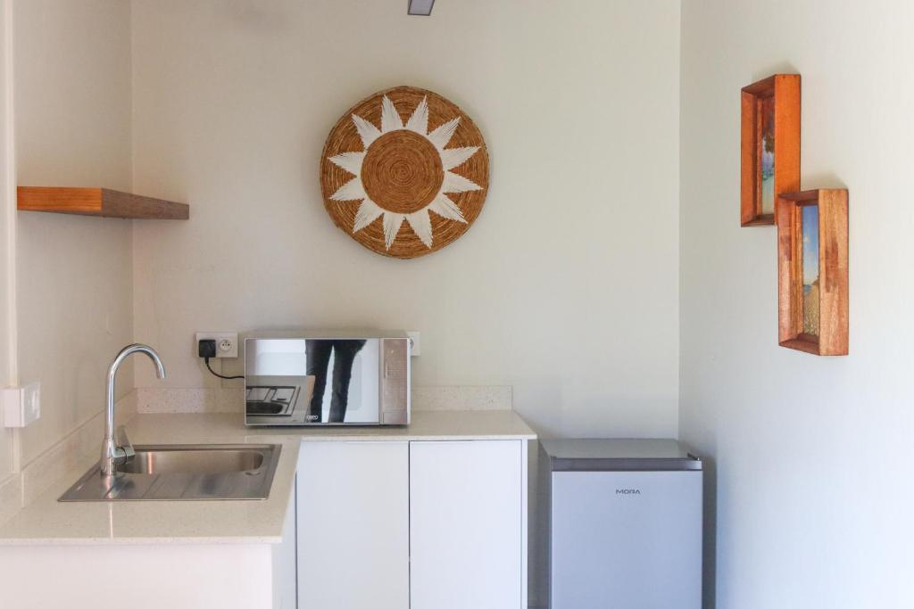 Flowers of Paradise numura virtuve ar izlietni un mikroviļņu krāsni.