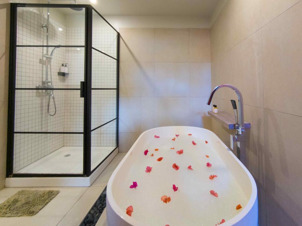 Viesnīcas Flowers of Paradise luksusa vannas istaba ar vannu un dušu.