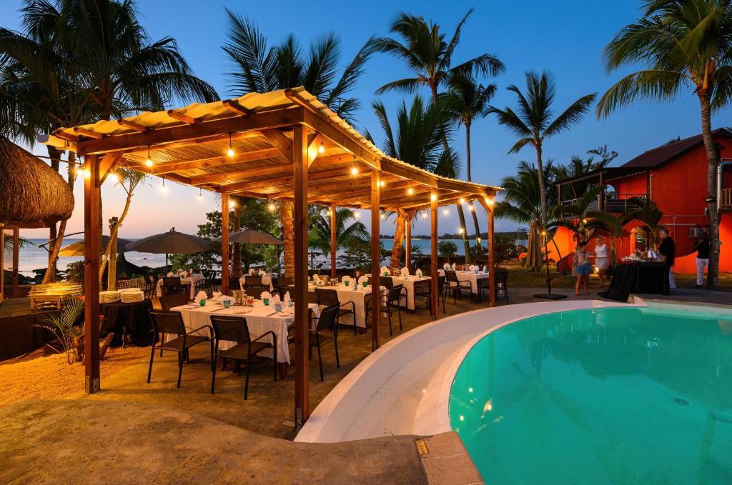 Flowers of Paradise restorāns pie baseina vakara apgaismojumā