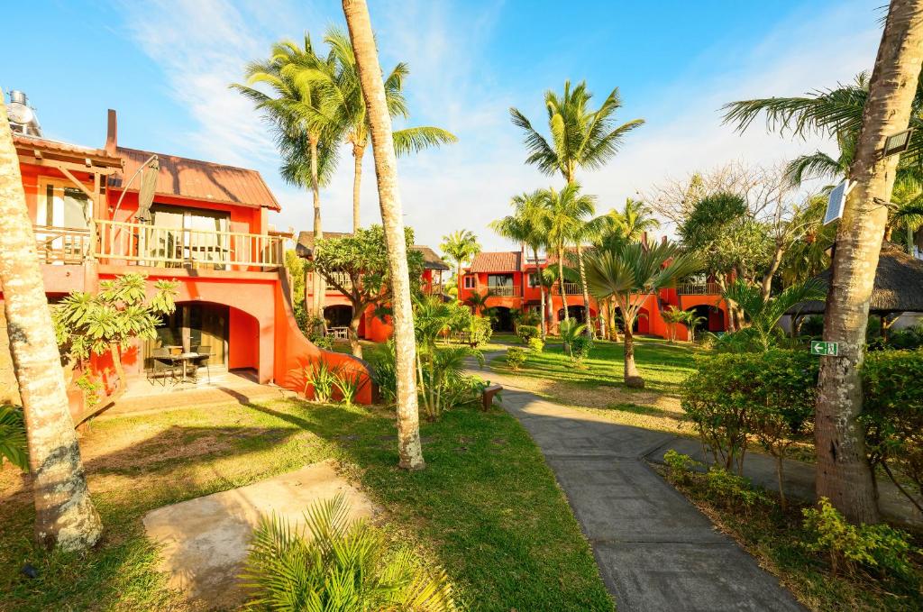 Tropu dārzs ar sarkanām ēkām Flowers of Paradise viesnīcā.