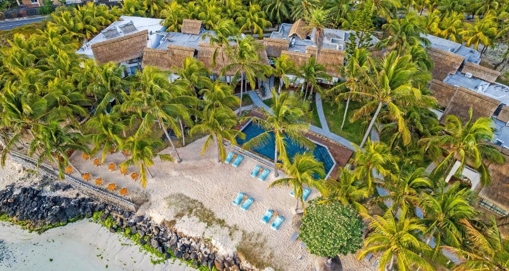 Seasense Boutique Hotel & Spa piekrastes skats ar baseinu un palmām.