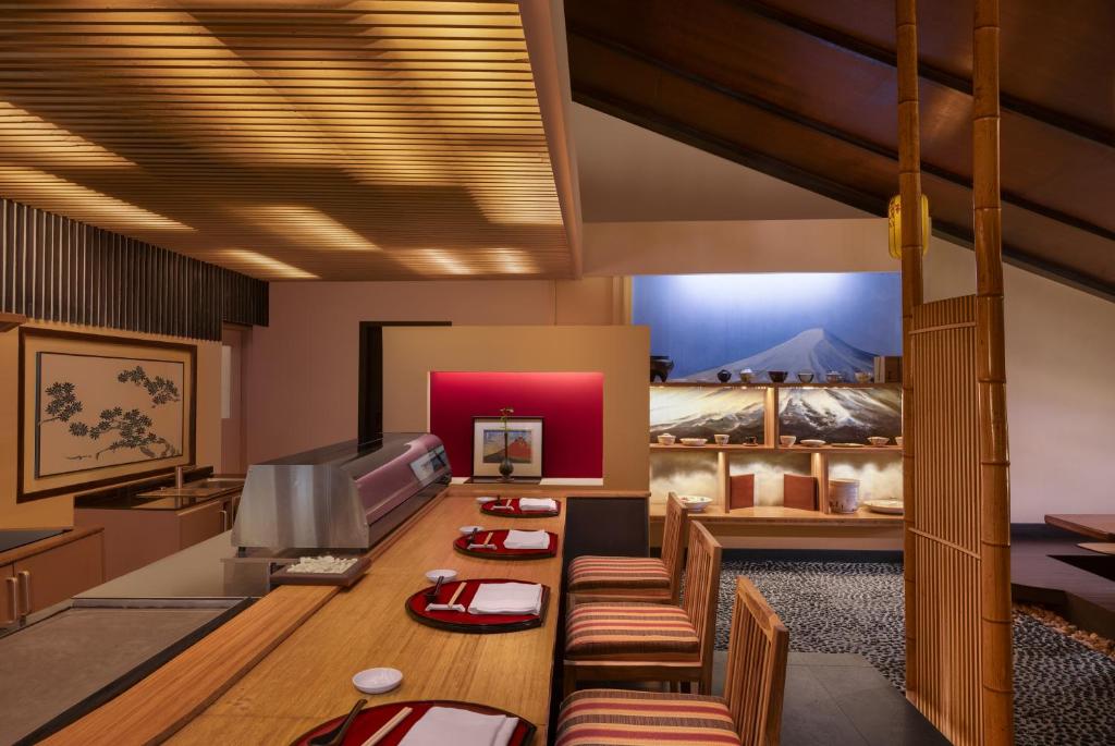 Mūsdienīgs japāņu restorāns ar elegantu interjeru, kas iekļauj koka elementus un tradicionālas dekorācijas. Sēdvietas pie bāra un mākslinieciskas gleznas rada patīkamu atmosfēru.