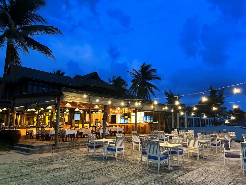 Restorāna āra zona ar apgaismojumu un palmām, kas rada patīkamu atmosfēru vakara maltītēm. Dīķa tuvumā izvietoti galdi un krēsli, kas aicina uz relaksējošu atpūtu.