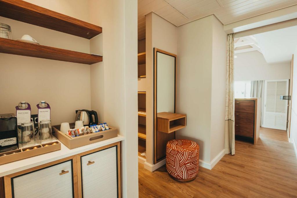 Mūsdienīga viesnīcas istaba ar kafijas pagatavošanas staciju, plauktiem un gaumīgu dekori. Rūpīgi iekārtota telpa ar koka grīdu un spilgtām krāsām.