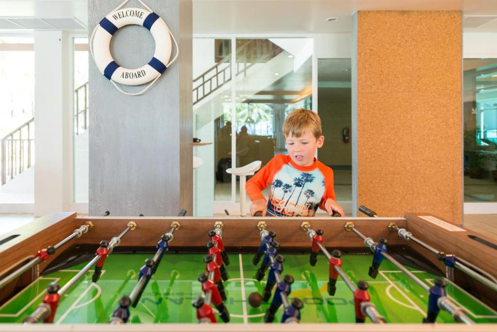 Bērns spēlē galda futbolu pie Katathani Phuket Beach Resort.
