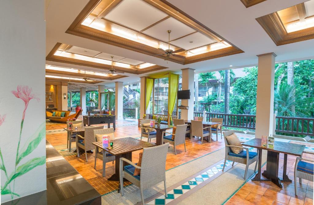 Mūsdienīgs restorāns ar plašu un gaišu telpu, kurā ir eleganti galdi un krēsli, kā arī zaļa apkārtne ārpus logiem. Ideāli piemērots relaksējošai maltītei.