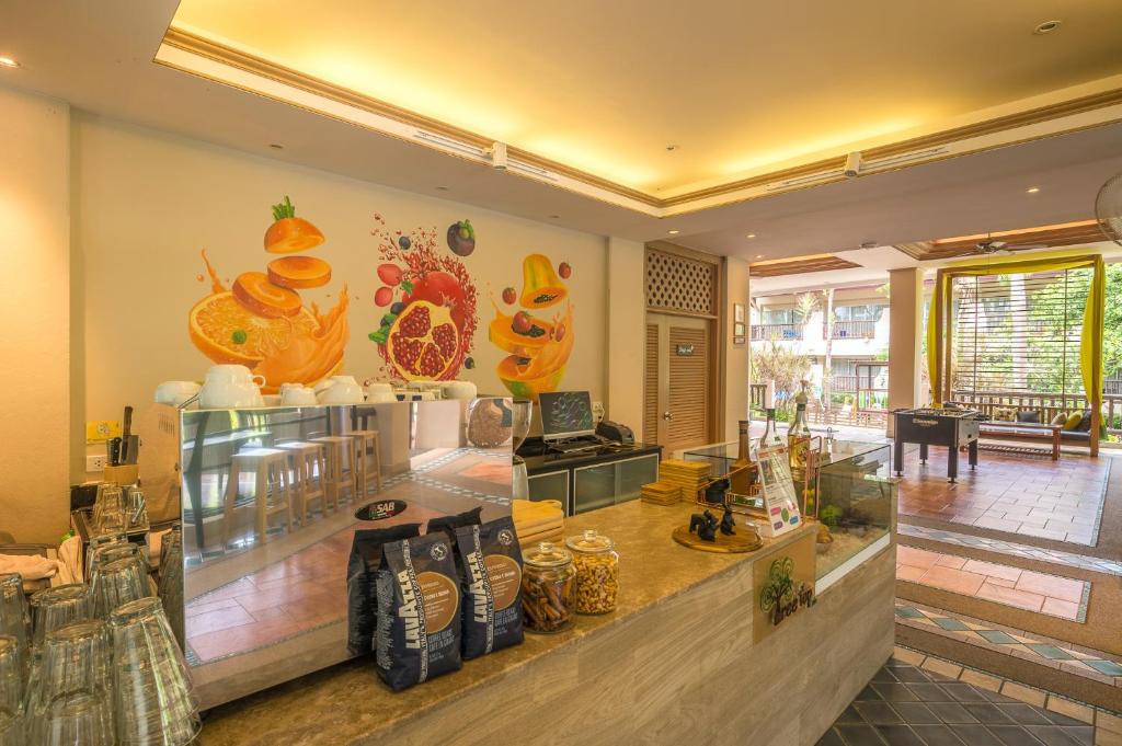 Augļu tematikas kafijas veikals ar modernu interjeru, atspoguļojot svaigu un veselīgu atmosfēru. Uz letes redzami kafijas maisiņi un dekoratīvi elementi.
