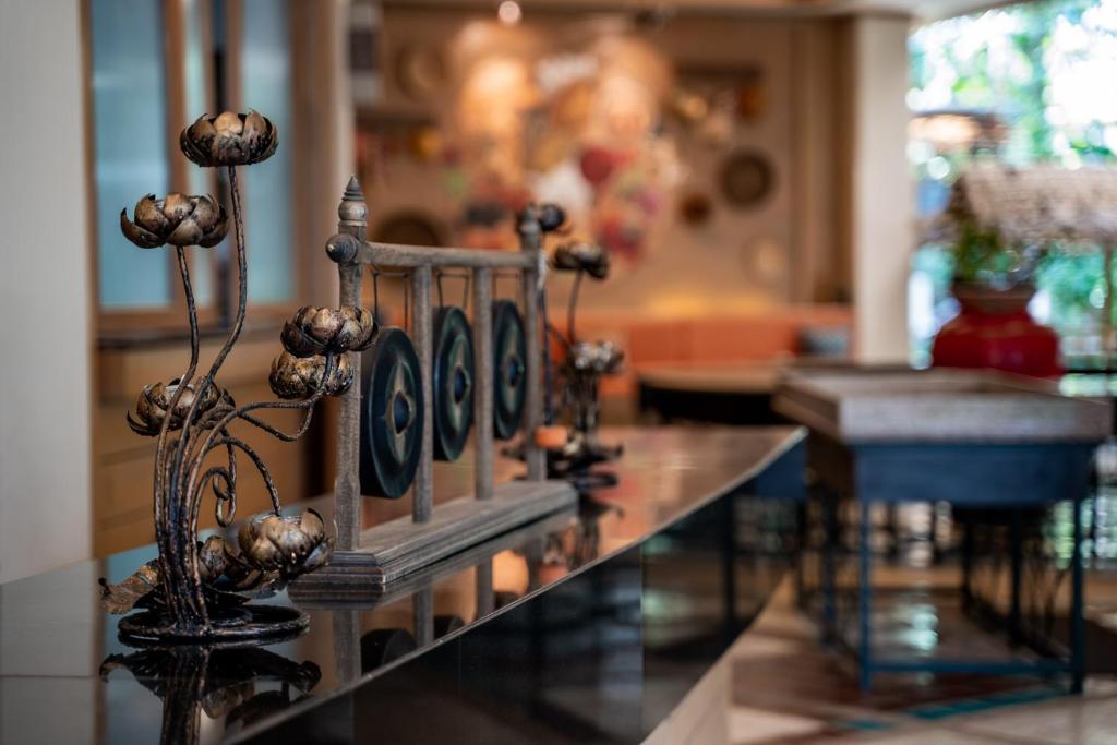 Mūsdienīgs interjers ar dekoratīvām ziedu lampām un stilīgu galdu, radot siltu un viesmīlīgu atmosfēru.