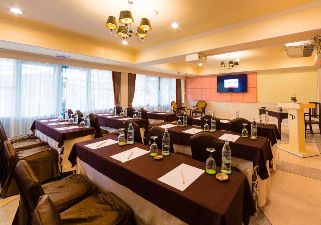 Konferenču telpa ar galdiem, ūdens pudelēm un rakstāmpiederumiem, kas gatavota sanāksmēm. Telpā ir dabisks apgaismojums un ekrāns prezentācijām.