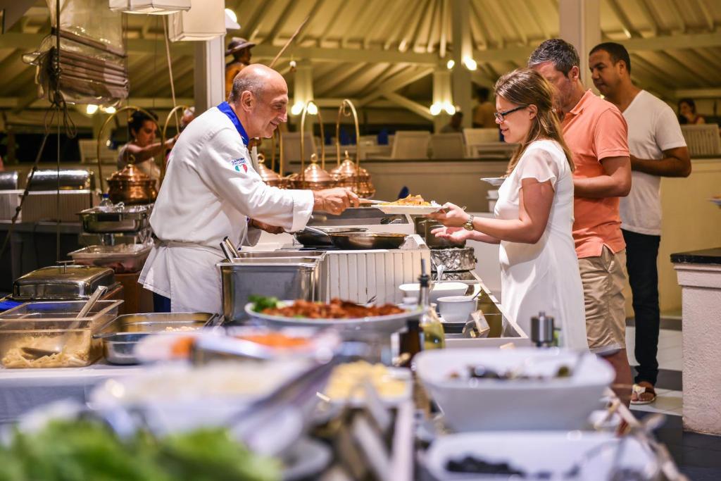 Kulinārijas pasākums, kur šefpavārs pasniedz ēdienus apmeklētājiem elegantā restorānā. Gaisotne ir viesmīlīga, ar daudzveidīgu ēdienu piedāvājumu.