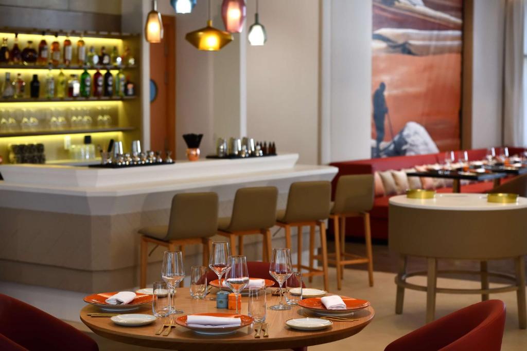 Mūsdienīgs restorāns ar elegantiem galdiem un krēsliem, kas piedāvā plašu dzērienu klāstu. Interjers apvieno siltas krāsas un stilīgas apgaismojuma detaļas.