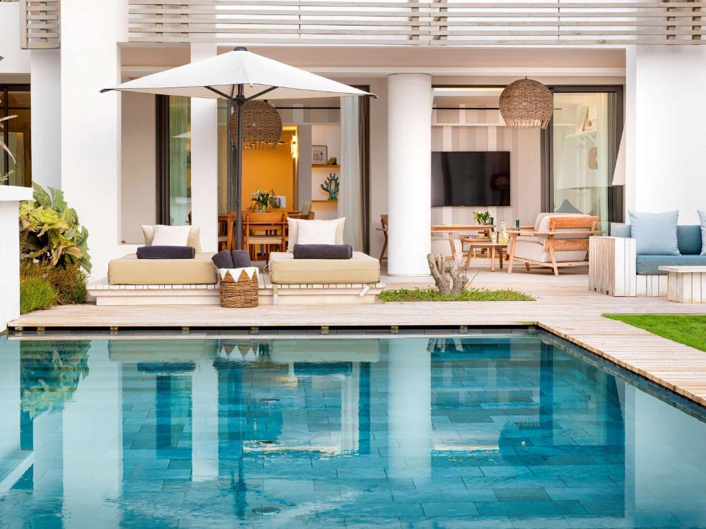 Mūsdienīgs ārējais baseins ar atpūtas zonu, kurā ir sauļošanās krēsli un saulessargs, kā arī eleganta terase, kas savienota ar māju. Ideāla vide relaksācijai un atpūtai.