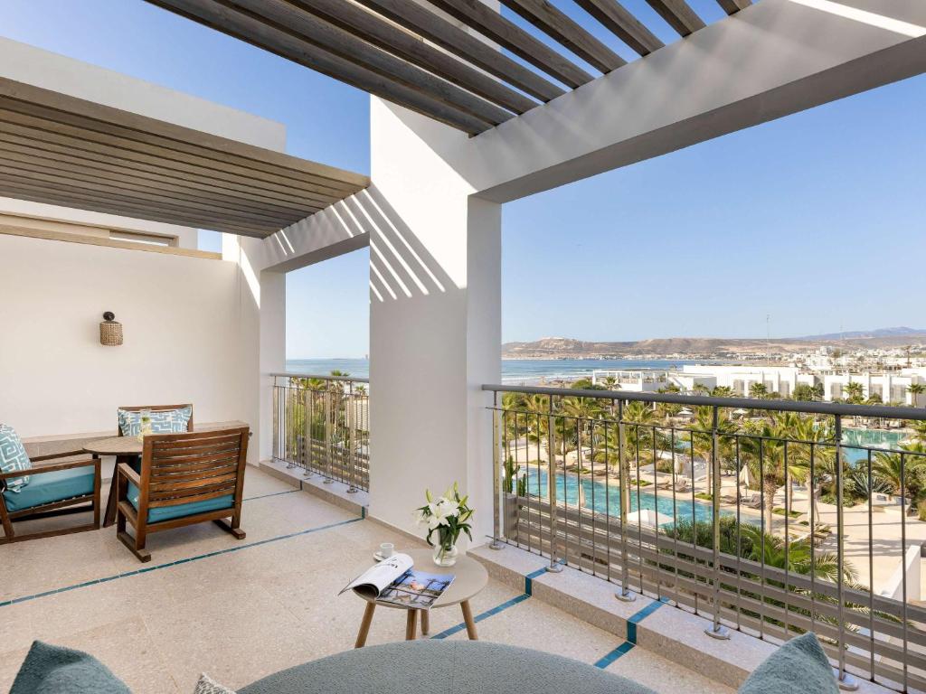 Mūsdienīgs balkons ar ērtu sēdvietu, no kura paveras skats uz baseinu un apkārtējo ainavu, kur valdina palmām un jūrai. Ideāla vieta relaksācijai un atpūtai.