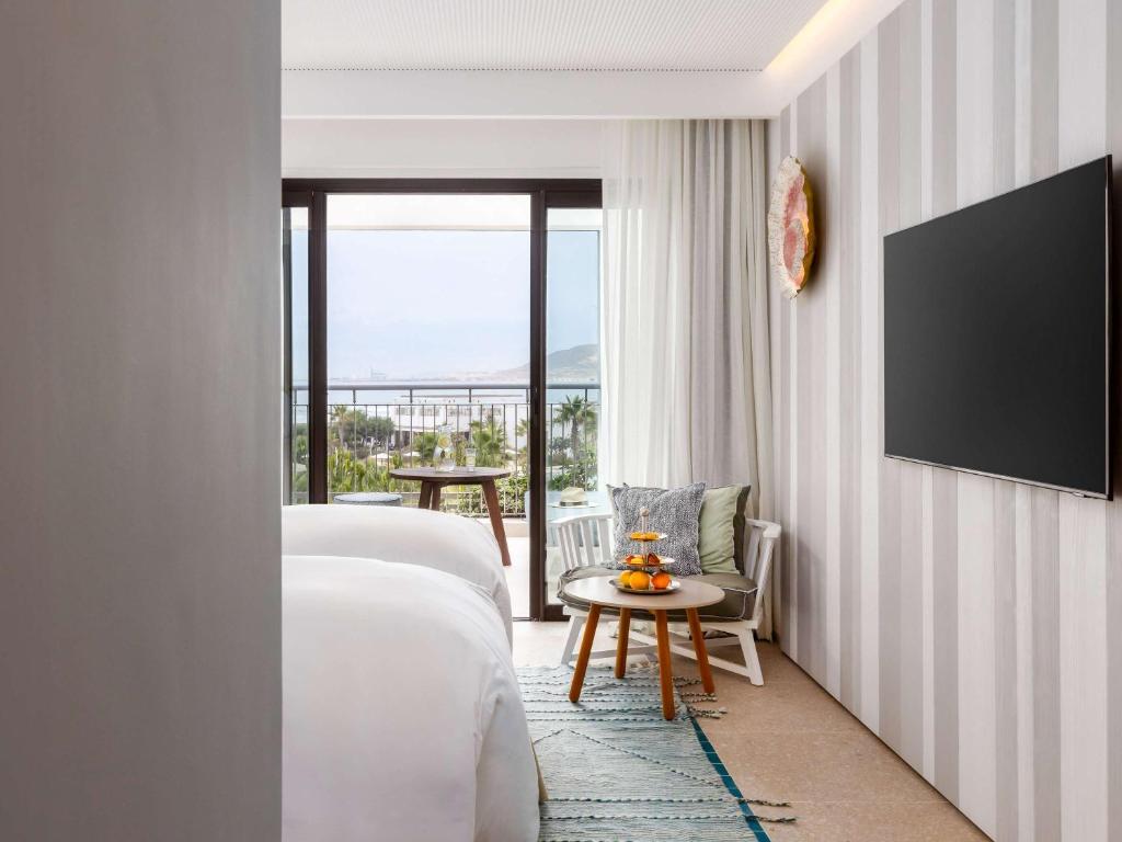 Mūsdienīgs viesnīcas numurs ar divām gultām, televizoru un skatu uz jūru. Telpā ir eleganti interjera elementi un patīkama atmosfēra.