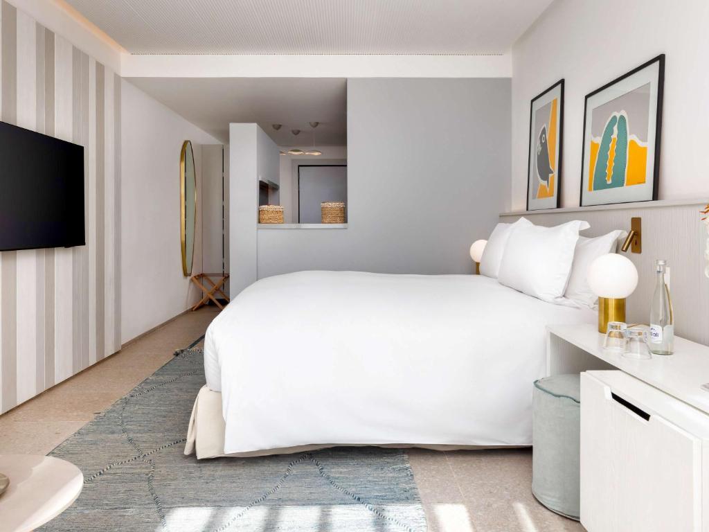 Mūsdienīgs viesnīcas numurs ar plašu gultu, stilīgām gleznām uz sienām un ērtu atpūtas zonu. Interjers piedāvā gaišas krāsas un modernus aksesuārus.