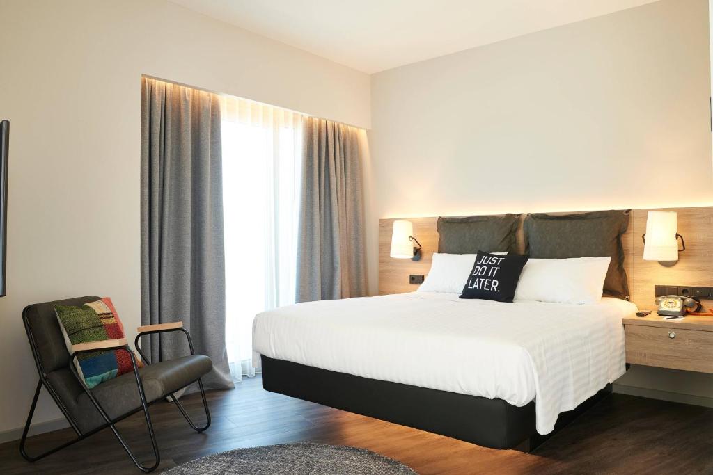 Mūsdienīgs viesnīcas numurs ar ērtu divguļamo gultu, stilīgu apgaismojumu un sēdvietu. Logu aizkari nodrošina gaismas plūsmu, radot patīkamu atmosfēru.