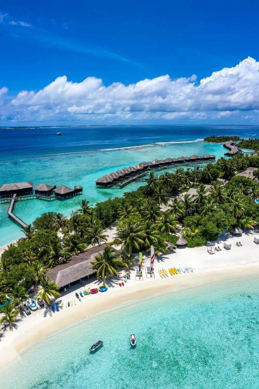 Tropu pludmale ar palmām un skaidru zilu ūdeni, kur redzami koka piestātņu kompleksi un laivas. Ideāla vieta atpūtai un ūdens sportam.