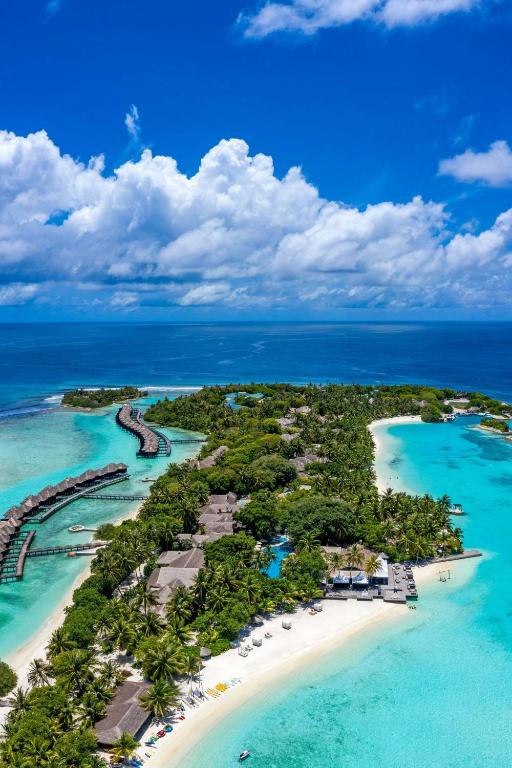 Tropu sala ar baltām pludmalēm un turku zilu ūdeni, kur redzami koka mājiņas un zaļumi. Ideāla vieta atpūtai un relaksācijai.