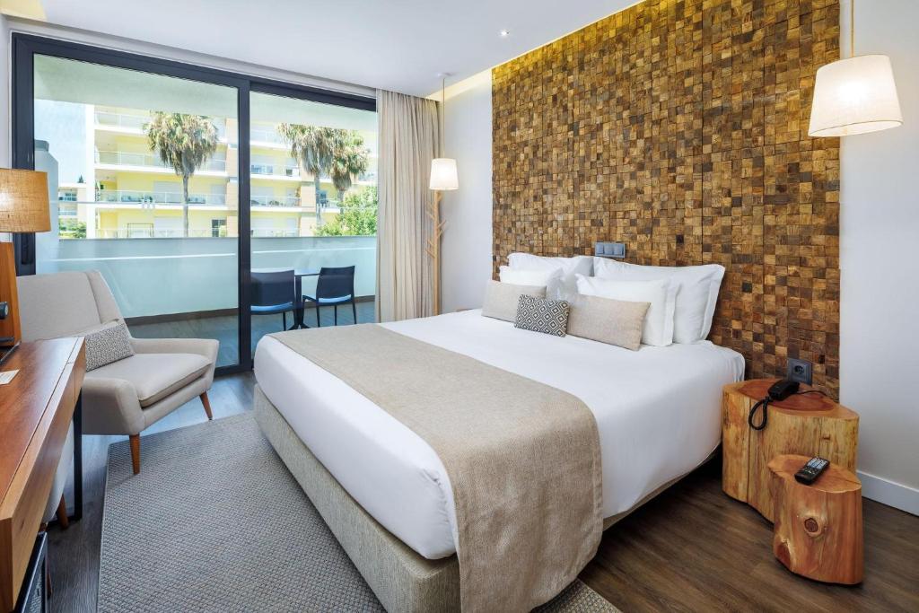 Moderns viesnīcas numurs ar koka akcentiem, plašām logiem un skatu uz terasi. Svaigs un gaišs interjers ar mīkstiem toņiem un ērtu mēbelēm.