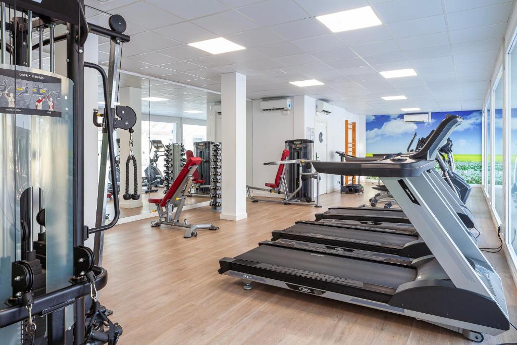 Mūsdienīgs sporta zāles interjers ar skrejceliņiem un trenažieriem, kas nodrošina ērtu vidi vingrošanai un fitnesa aktivitātēm. Gaismas un plašums rada patīkamu atmosfēru.