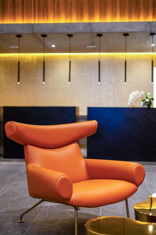Mūsdienīgs oranžs krēsls Melia Casa Maya viesnīcas vestibilā