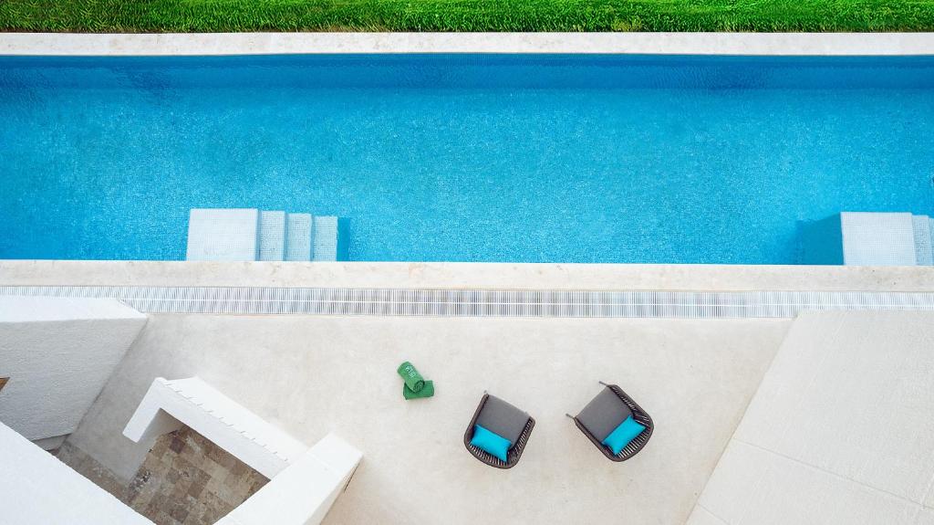 Melia Casa Maya baseins ar divām krēslām piekrastē