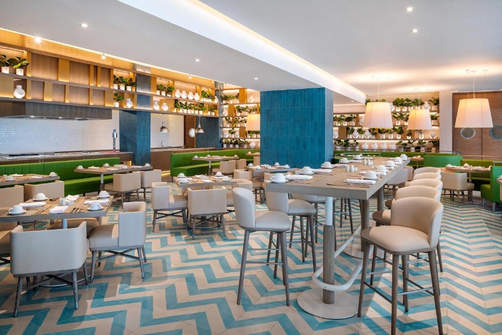 Moderns restorāns Melia Casa Maya ar zaļām un zilo flīzēm.