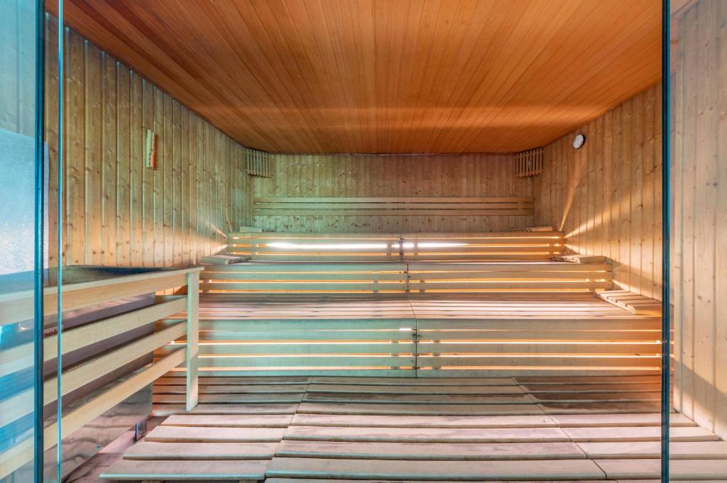 Mūsdienīga sauna ar koka interjeru un izgaismotām plauktiem, kas rada relaksējošu atmosfēru. Ideāla vieta atpūtai un veselības uzlabošanai.