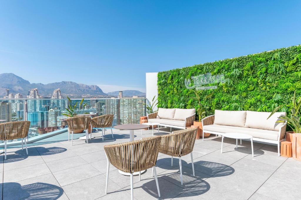 Mūsdienīga jumta terase ar skatu uz pilsētu un kalniem, kurā ir stilīgas mēbeles un zaļums. Ideāla vieta relaksācijai un baudīšanai.