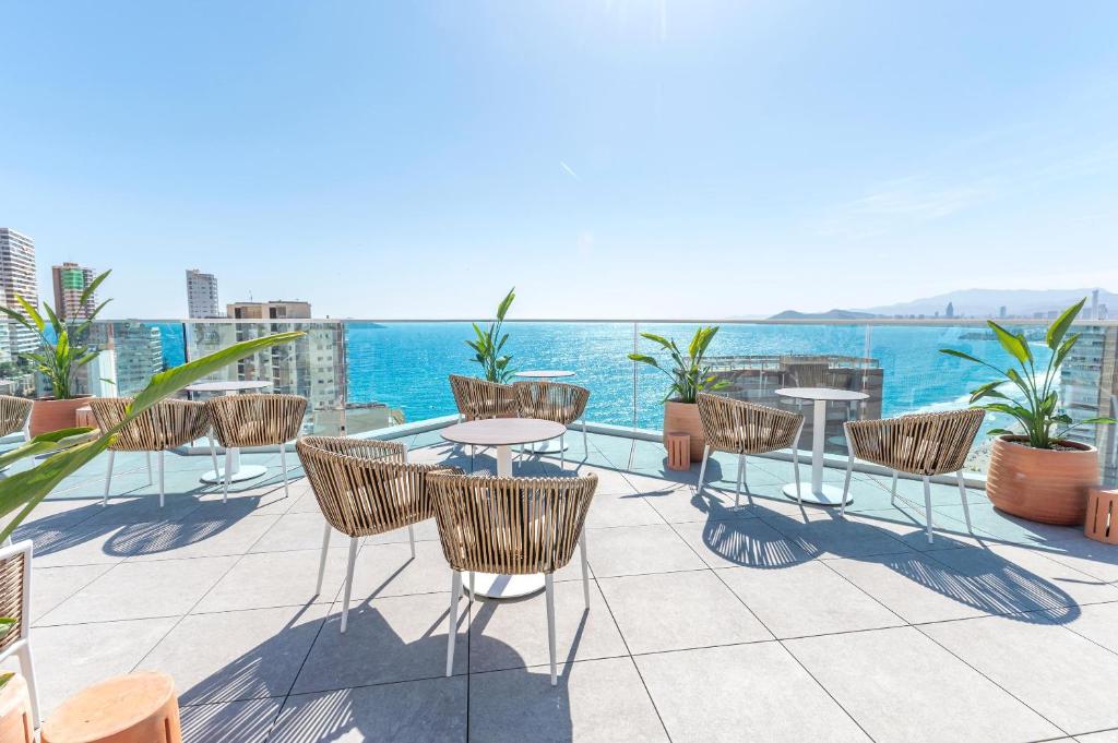 Terases zona ar skatu uz jūru, kur ir modernas krēsli un galdi, apstādīta ar augiem. Ideāla vieta atpūtai un relaksācijai.