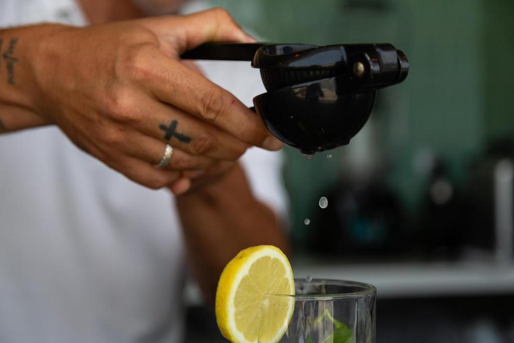 Citrusu sulu spiedējs, kas izspiež citronu sulas, piepildot glāzi ar svaigām sastāvdaļām.