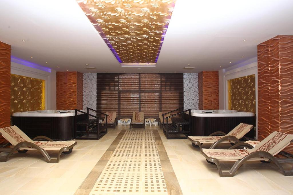 Mūsdienīgs spa ar relaksējošām atpūtas zonām un aromātisku atmosfēru, kurā redzami masāžas krēsli un burbuļvanna. Ideāls vieta atpūtai un labsajūtai.