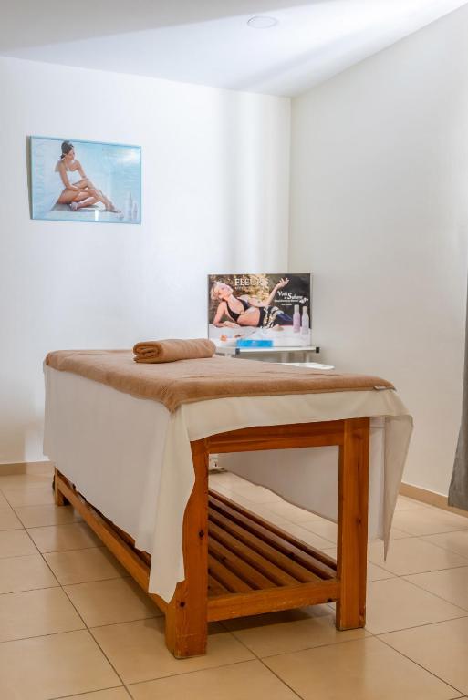 Masažu galdiņš ar dvieli un reklāmas materiāli par skaistumkopšanas produktiem relaksējošā vidē.