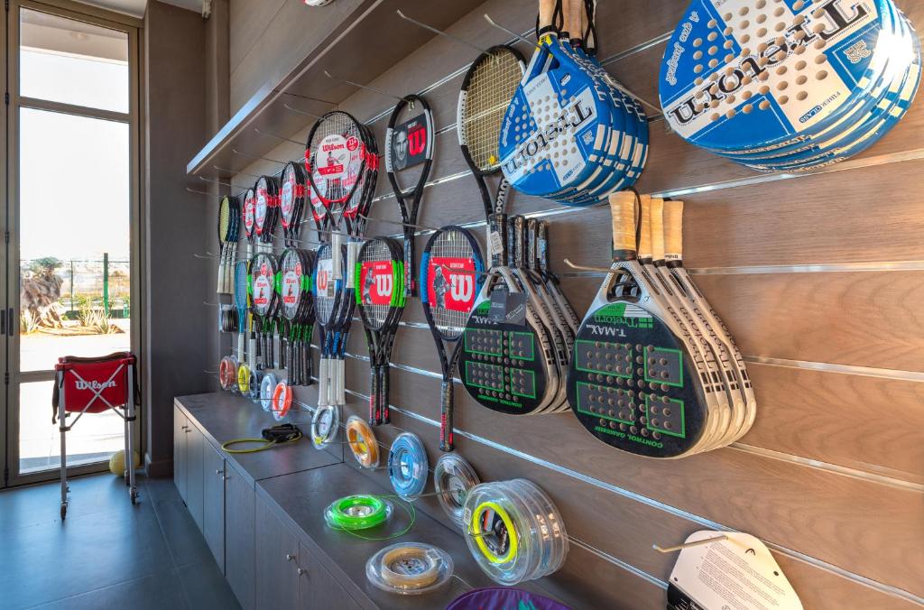 Sienā izvietoti dažādi tenisa un padel raketi, kā arī aksesuāri. Interjers ir gaišs un moderns, radot sportisku atmosfēru.