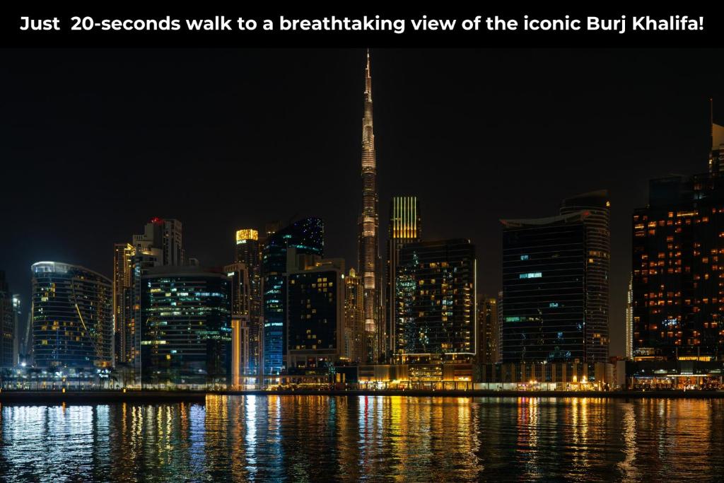 Elpu aizraujošs skats uz ikonisko Burj Khalifa naktī, ar mūsdienīgām ēkām un atspīdumiem ūdenī. Ideāla vieta, lai izbaudītu pilsētas skaistumu.
