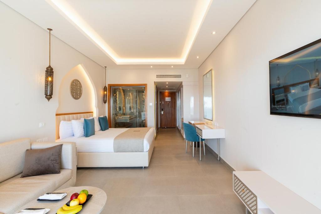 Moderns numurs Sunrise Remal Beach Resort ar komfortablu gultu un televizoru.