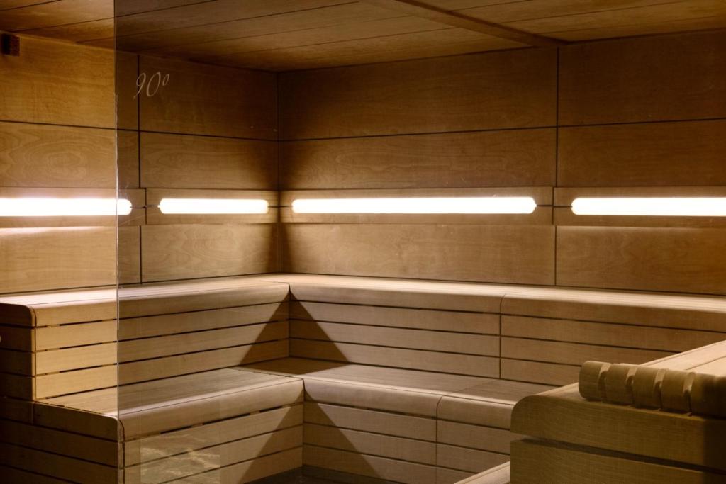 Mūsdienīga koka sauna ar apgaismojumu un minimālistisku dizainu, kas nodrošina relaksējošu vidi. Ideāla vieta veselības un labsajūtas uzlabošanai.