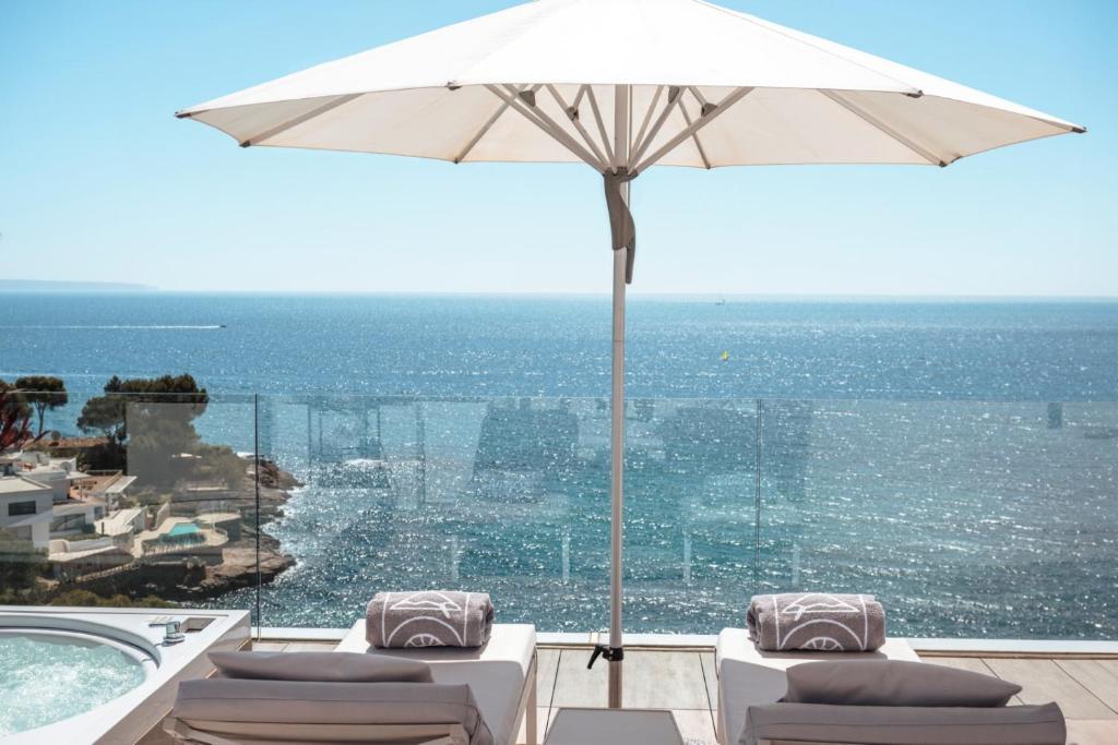 Laba atpūtas zona ar saules jumtu un šikiem krēsliem, kas skatās uz mierīgu jūru un skatu uz piekrasti. Ideāla vieta relaksācijai un atpūtai.