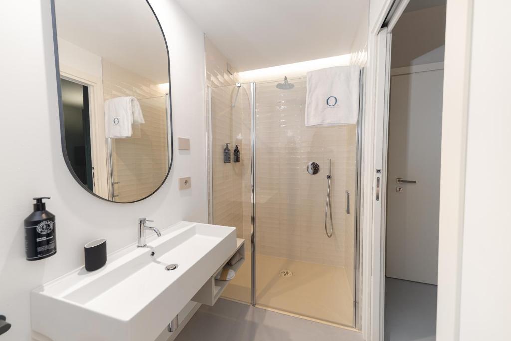 Mūsdienīga vannas istaba ar dušu un elegantu spoguli.