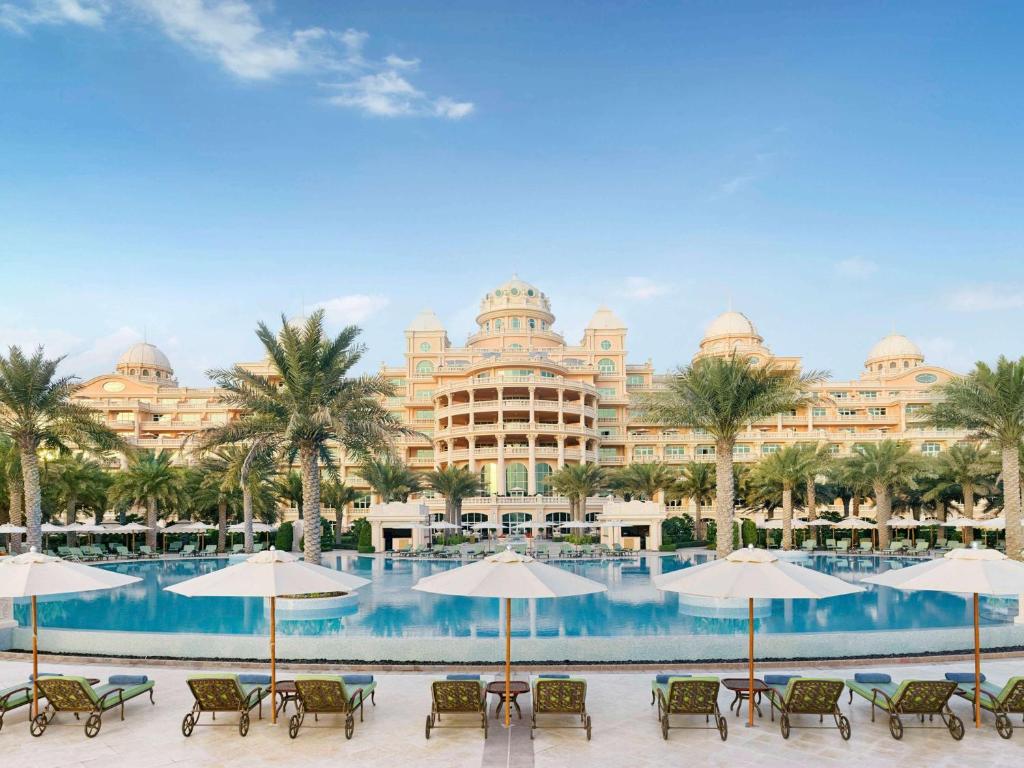 Greznas viesnīcas un baseina skats ar palmām un sauļošanās krēsliem. Ideāla vieta relaksācijai un atpūtai.